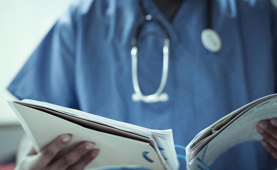 Doctor in scrubs reviewing patient file